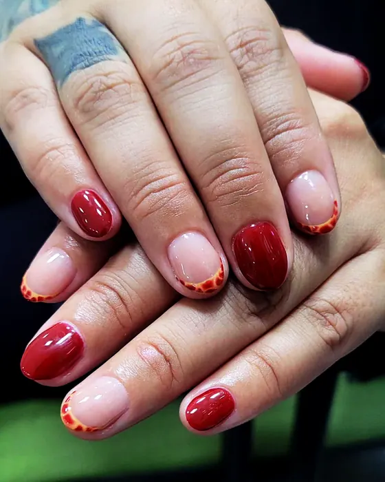 Manicuría en tonos rojo y nude, con diseño en las puntas