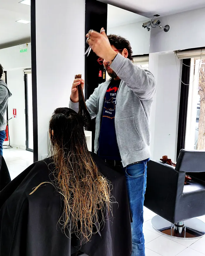 Maximiliano Puyol cortando el pelo a una clienta en La Maison